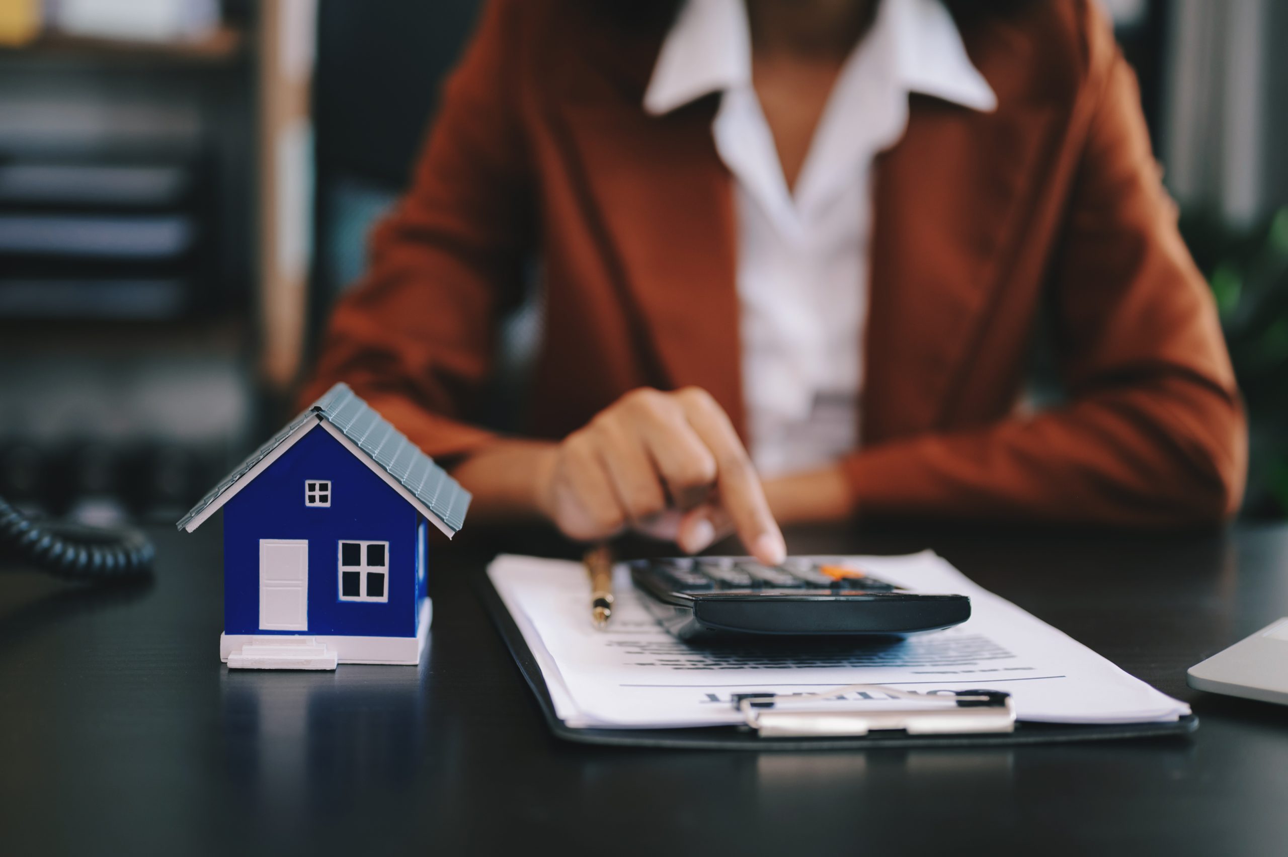 Real estate broker agent presenting and consult to customer to decision making sign insurance form agreement, home model, concerning mortgage loan offer in office